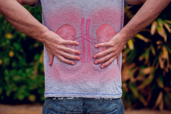 People, health care and medicine concept - unhappy man suffering from pain in back or kidneys sitting on bench on street. Source: DepositPhotos